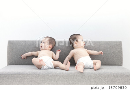 ソファーに座っている双子の赤ちゃん 13709630