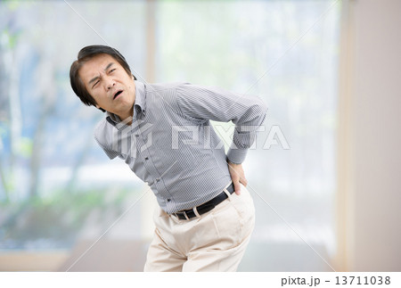 自宅リビングの窓際に立っているカジュアルウェアー姿の中年男性 自宅リビングの窓際に立っているカジュアルウェアー姿の中年男性 13711038