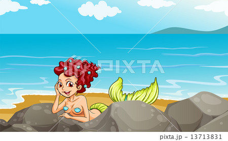 A mermaid at the seashore near the rocks 13713831