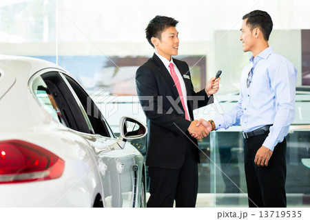 Asian Car Salesman selling auto to customer 13719535