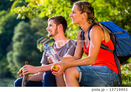 Couple hiking in summer drinking water 13719903