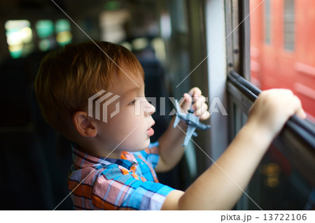 Little boy with toy looking out of train window Little boy with toy looking out of train window 13722106