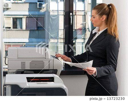 business woman working on printer business woman working on printer 13723230