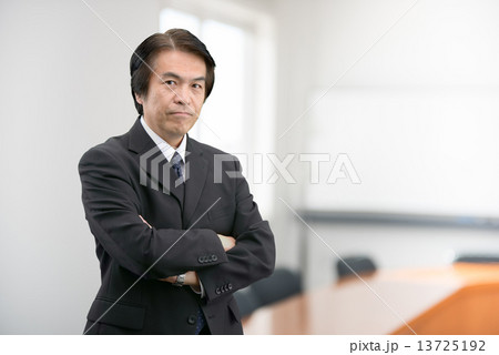 会社の会議室に立っているスーツ姿の中年男性 会社の会議室に立っているスーツ姿の中年男性 13725192