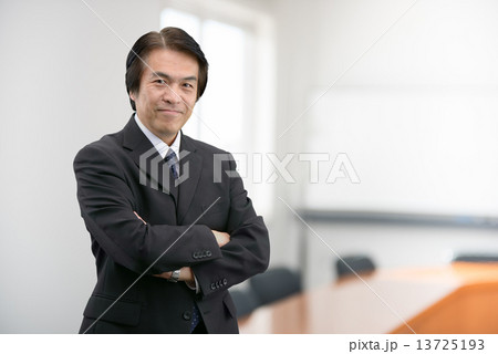 会社の会議室に立っているスーツ姿の中年男性 会社の会議室に立っているスーツ姿の中年男性 13725193