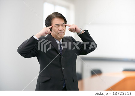 会社の会議室に立っているスーツ姿の中年男性 会社の会議室に立っているスーツ姿の中年男性 13725213
