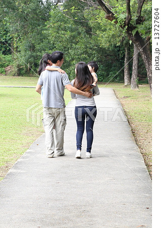 Parent and children walk in the park  13727604