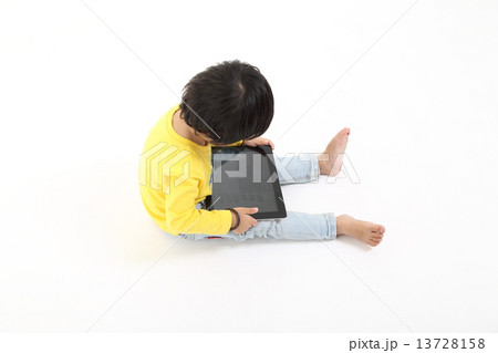 Child playing with Tablet pc touch pad  13728158