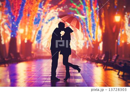 Couple with umbrella kissing at night alley. 13728303