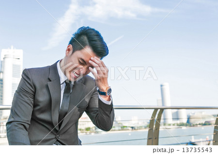 Frustrated young business man with a headache 13735543