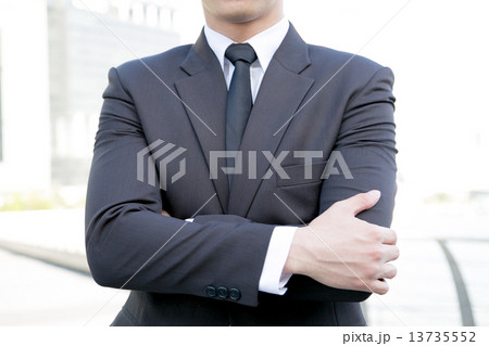 A business man standing with arms folded A business man standing with arms folded 13735552