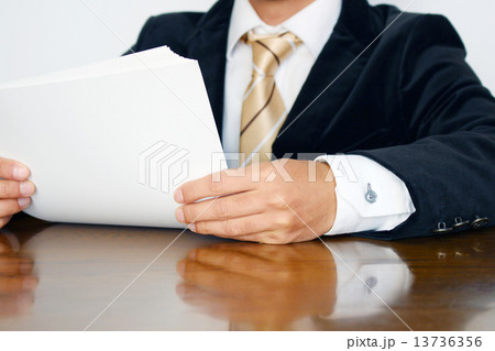 資料に目を通すビジネスマン 資料に目を通すビジネスマン 13736356