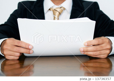 資料に目を通すビジネスマン 13736357