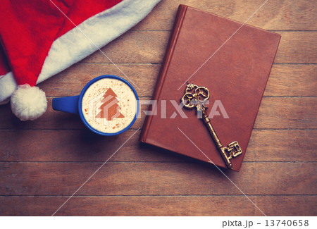 Cappuccino with key and book on wooden table. Cappuccino with key and book on wooden table. 13740658
