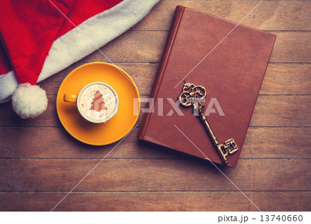 Cappuccino with key and book on wooden table. 13740660