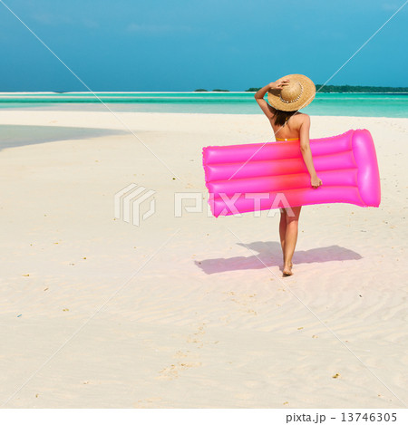 Woman with pink inflatable raft at the beach Woman with pink inflatable raft at the beach 13746305