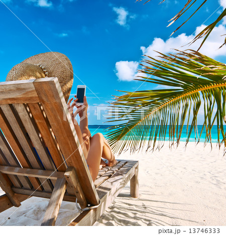 Young woman with mobile phone at the beach 13746333