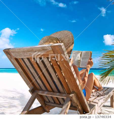 Young woman reading a book at beach 13746334