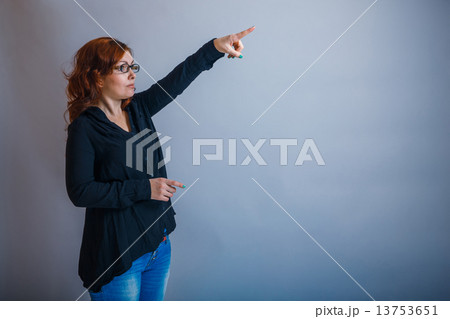 European -looking  woman  of  30  years is pointing in the  dire 13753651