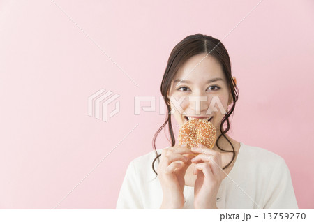 ドーナツを食べる若い女性 13759270