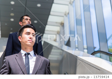 Business man on escalator 13759414