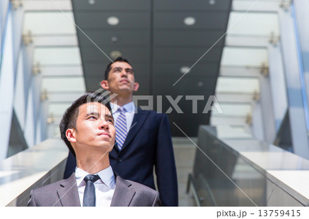 Business man on escalator 13759415