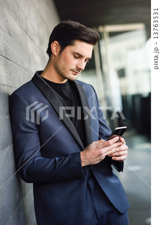 Attractive young businessman on the phone in an office building 13763531