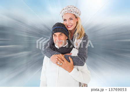 Composite image of happy couple in winter fashion embracing Composite image of happy couple in winter fashion embracing 13769053