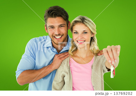 Composite image of attractive young couple showing new house key 13769202