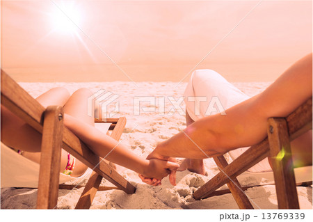 Couple resting on deck chairs 13769339