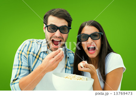 Composite image of attractive young couple watching a 3d movie Composite image of attractive young couple watching a 3d movie 13769473