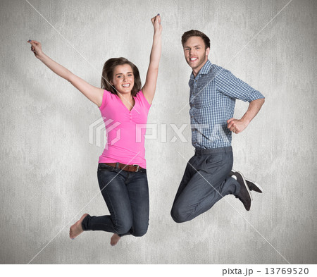 Composite image of cheerful young couple jumping Composite image of cheerful young couple jumping 13769520