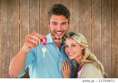 Composite image of attractive young couple showing new house key 13769651
