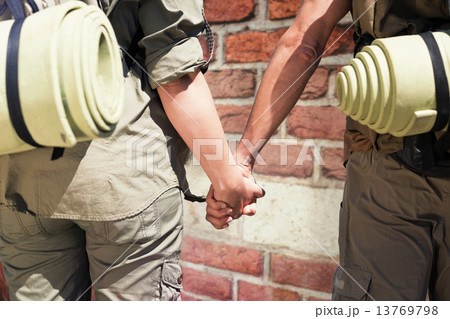 Composite image of hitch hiking couple standing holding hands on Composite image of hitch hiking couple standing holding hands on 13769798
