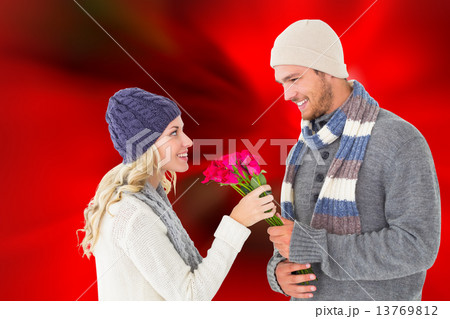 Composite image of attractive man in winter fashion offering ros Composite image of attractive man in winter fashion offering ros 13769812