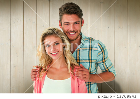 Composite image of attractive young couple smiling at camera Composite image of attractive young couple smiling at camera 13769843