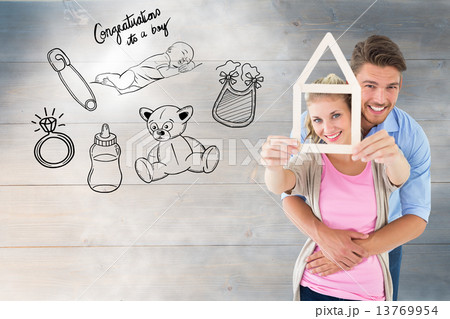 Composite image of young couple hugging and holding house outlin Composite image of young couple hugging and holding house outlin 13769954