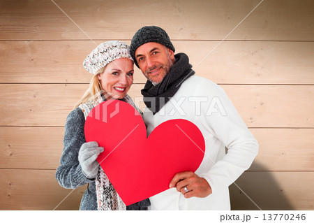 Composite image of smiling couple in winter fashion posing with 13770246