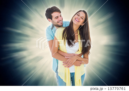 Composite image of happy casual couple smiling and hugging 13770761