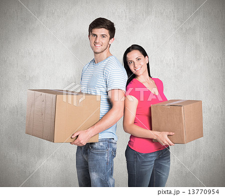 Composite image of young couple holding moving boxes Composite image of young couple holding moving boxes 13770954
