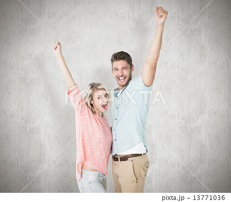 Composite image of attractive couple smiling and cheering 13771036