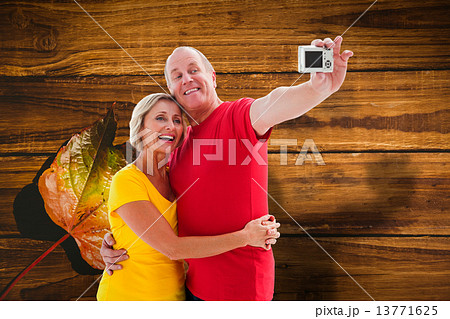 Composite image of happy mature couple taking a selfie together 13771625