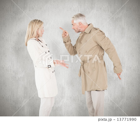 Composite image of angry couple fighting in trench coats 13771990