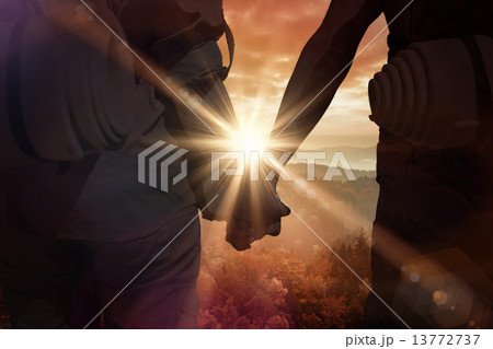 Composite image of hitch hiking couple standing holding hands on 13772737