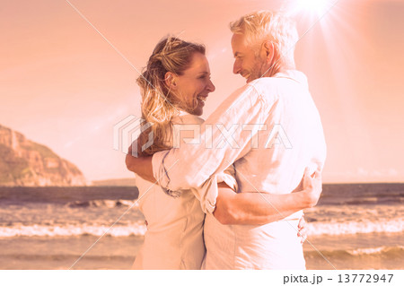 Happy couple on the beach smiling at each other Happy couple on the beach smiling at each other 13772947