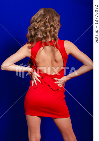 Beautiful girl with long hair in a red dress in the studio 13776082