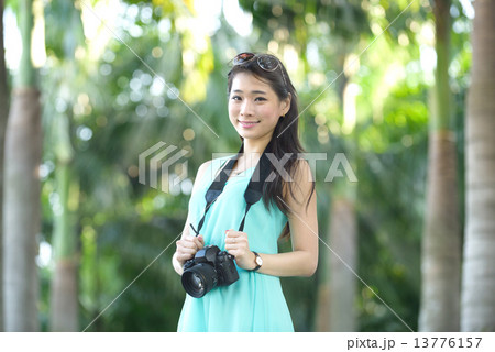 One young Chinese woman taking picture with DSLR  13776157
