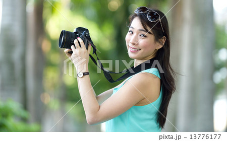 One young Chinese woman taking picture with DSLR  13776177