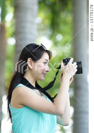 One young Chinese woman taking picture with DSLR  13776178