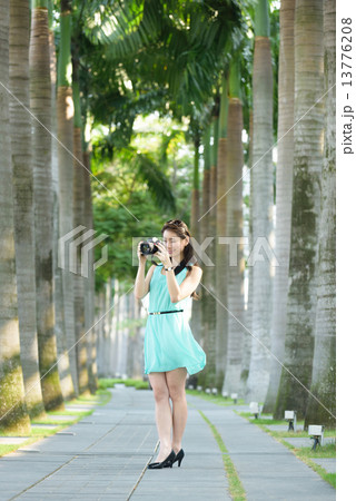 One young Chinese woman taking picture with DSLR  13776208
